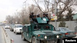 Afghan policeman arrive at the site of a blast and gunfire in Kabul, Afghanistan March 8, 2017.