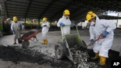 ARCHIVO - Trabajadores arrojan drogas incautadas mezcladas con productos de desecho para crear una capa de concreto, en una instalación en Cayambe, Ecuador, el viernes 3 de marzo de 2023.
