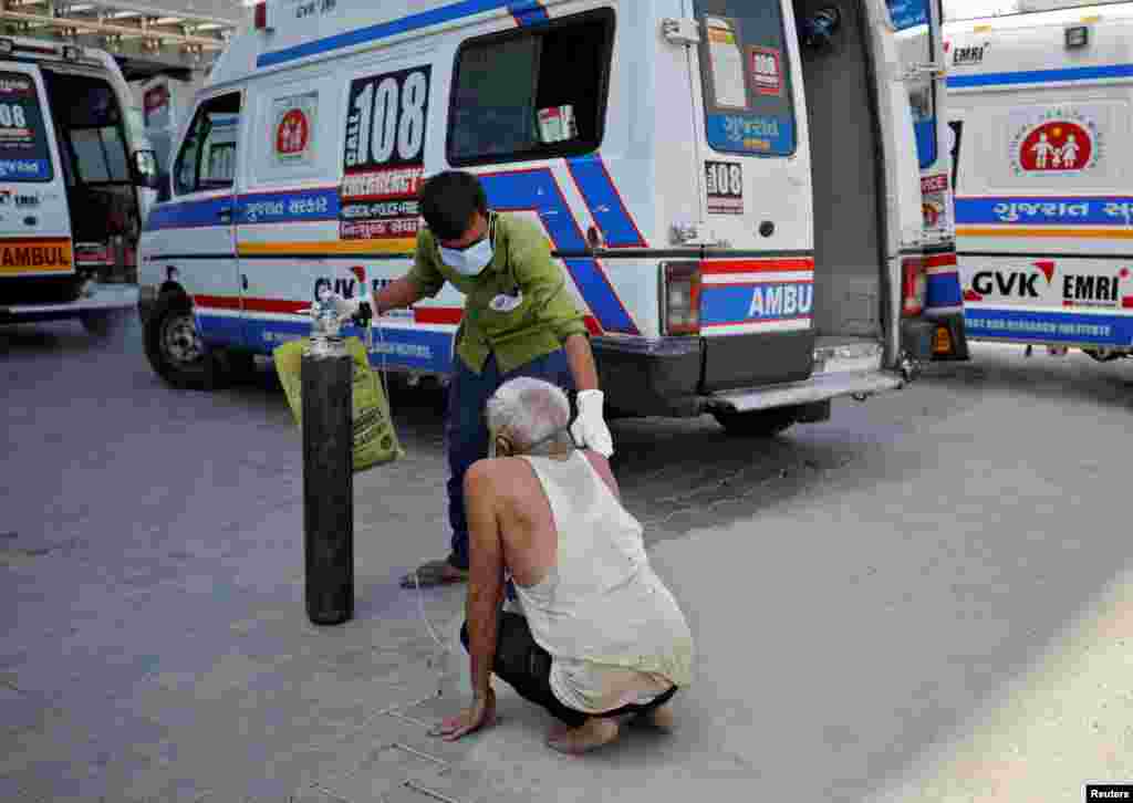 A patient with breathing problem is helped by a relative to enter a COVID-19 hospital for treatment in Ahmedabad. India now has reported more than 15 million coronavirus infections.