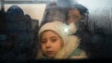 资料照：2022年3月2日，一名逃离乌克兰冲突的女孩在穿过帕兰卡附近的摩尔多瓦-乌克兰边境检查站后从一辆开往摩尔多瓦首都基希讷乌的巴士里朝外看。（法新社）