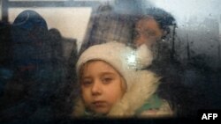یک دختری خردسال که از جنگ فرار کرده، پس از عبور از تلاشی مرزی مولدافا از داخل یک بس مسافربری به بیرون نگاه می کند