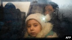ARHIVA - Devojčica gleda kroz prozor autobusa kojim se evakuiše iz Ukrajine u Moldaviju, 2. marta 2022 (Foto: AFP/Nikolay Doychinov)