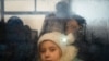 Una niña que huye del conflicto en Ucrania mira desde el interior de un autobús que se dirige a la capital de Moldavia, Chisinau, después de cruzar el puesto de control fronterizo entre Moldavia y Ucrania cerca de la ciudad de Palanca, el 2 de marzo de 2022.