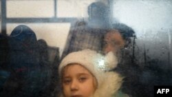 Una niña que huye del conflicto en Ucrania mira desde el interior de un autobús que se dirige a la capital de Moldavia, Chisinau, después de cruzar el puesto de control fronterizo entre Moldavia y Ucrania cerca de la ciudad de Palanca, el 2 de marzo de 2022.