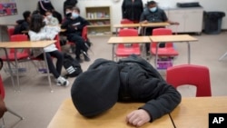An unidentified student rests on his desk as the Mojave Unified School District. (AP Photo/Damian Dovarganes)