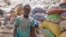 FILE - A dust-covered miner walks at a gold mine in Bouda, Burkina Faso, Feb. 23, 2020,
