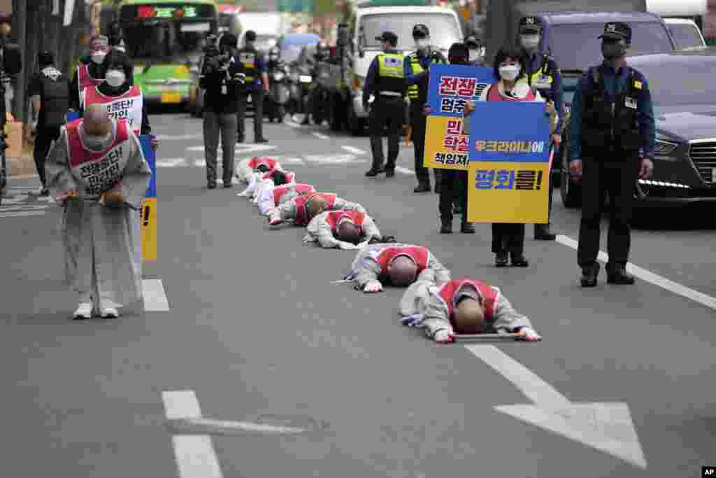 South Korean Buddhist monks, and members of civic groups prostrate themselves on a road heading to the Russian Embassy in Seoul to wish for peace and stop the war in Ukraine.