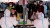 Trabajadores sanitarios atienden a ciudadanos que se realizan pruebas de COVID-19, en Guangzhou, en la provincia sureña china de Guangdong, el 25 de marzo de 2022.