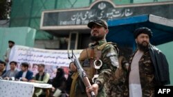 Anggota pasukan Taliban berjaga di tengah demo yang digelar warga Afghanistan di depan Kedutaan Besar Iran di Kabul, pada 11 April 2022. Mereka memprotes dugaan penyiksaan yang dialami oleh pengungsi asal Afghanistan di Iran. (AFP/Wakil Kohsar)