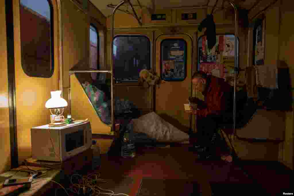 A young man eats inside a subway car, as residents find shelter from shelling in a metro station in Kharkiv amid Russia&#39;s invasion of Ukraine, April 11, 2022.