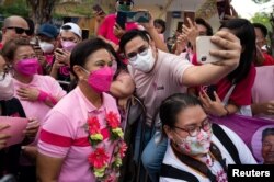 Seorang pendukung Wakil Presiden Filipina Leni Robredo, calon presiden untuk pemilihan 2022, berfoto selfie saat kampanye di Angeles City, Provinsi Pampanga, Filipina, 9 April 2022. (REUTERS/Lisa Marie David)