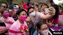 Seorang pendukung Wakil Presiden Filipina Leni Robredo, calon presiden untuk pemilihan 2022, berfoto selfie saat kampanye di Angeles City, Provinsi Pampanga, Filipina, 9 April 2022. (Foto: REUTERS/Lisa Marie David)