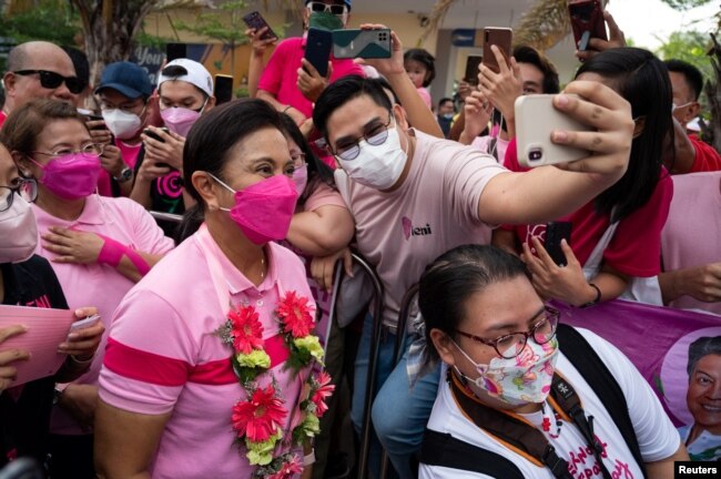 Seorang pendukung Wakil Presiden Filipina Leni Robredo, calon presiden untuk pemilihan 2022, berfoto selfie saat kampanye di Angeles City, Provinsi Pampanga, Filipina, 9 April 2022. (REUTERS/Lisa Marie David)