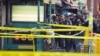 Polisi New York berkumpul di pintu masuk halte kereta bawah tanah (subway) di wilayah Brooklyn, New York, Selasa, 12 April 2022. Beberapa orang terluka akibat serangan pada jam sibuk pagi hari, di stasiun kereta bawah tanah di New York City. (AP/John Minchillo)