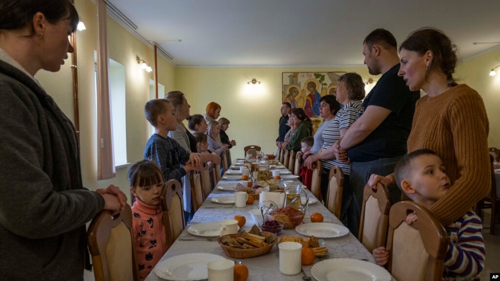 Internally displaced people make prayers before eating dinner, at the Hoshiv Women Monastery April 6, 2022. (AP Photo/Nariman El-Mofty)