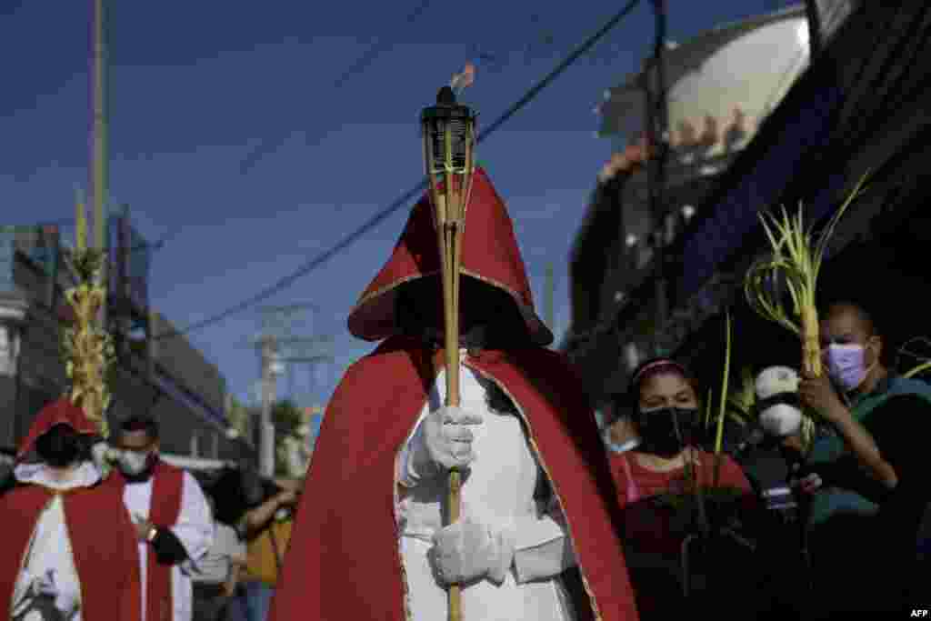 Fieles católicos participan en la tradicional procesión del Domingo de Ramos en el centro histórico de San Salvador, el 10 de abril de 2022.