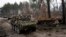 Soldados ucranianos captados el 31 de marzo mientras transitaban sobre vehículos blindados junto a un tanque ruso destruido en las afueras de Kiev. Alemania y otros países europeos refuerzan la ayuda al ejército del país invadido por Rusia.