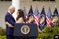 President Joe Biden hugs Mia Tretta, a survivor of the Saugus Hight School shooting in Santa Clarita, Calif., after she spoke in the Rose Garden of the White House in Washington, April 11, 2022.