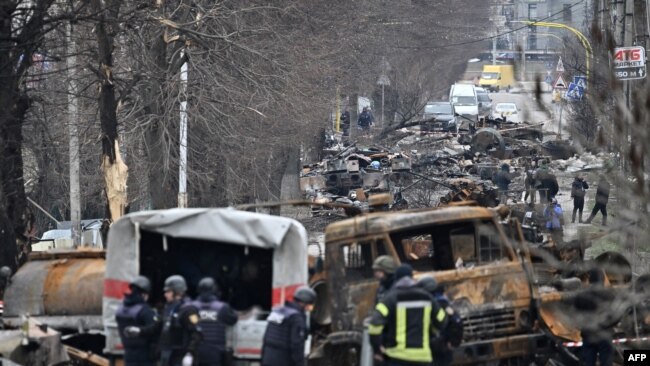 Inxhinierët ukrainas përpiqen të pastrojnë minat në rrugët e qytetit Bucha ku u gjendën trupa të shumta viktimash (5 prill 2022)