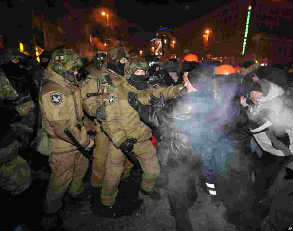 Riot police pull pro-European Union activists out from their camp in Independence Square in Kyiv, Dec. 11, 2013. 