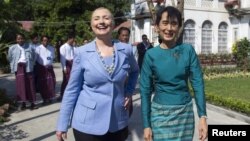  U.S. Secretary of State Hillary Clinton (L) and Myanmar's pro-democracy leader Aung San Suu Kyi tour the grounds after their meeting at Suu Kyi's house in Yangon December 2, 2011.