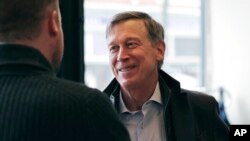 FILE - Former Democratic Colorado Governor John Hickenlooper talks with AmeriCorps members in Manchester, N.H., March 22, 2019. 