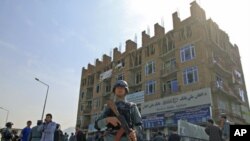 Afghan policeman stand guard after a battle with insurgents who took over a building in Kabul, Afghanistan, April 16, 2012.