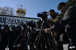 Jurnalis meliput aksi protes perempuan yang mendukung rezim Taliban di depan kedutaan AS di Kabul pada 26 Januari 2022. (Foto: AFP)