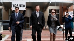 FILE - Paul Manafort, center, President Donald Trump's former campaign chairman, walks with this wife Kathleen Manafort, right, and Jason Maloni, Manafort's spokesman, left, as they arrive for an arraignment hearing in Alexandria, Va., March 8, 2018.