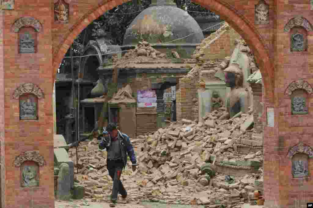 Seorang pria Nepal menangis ketika berjalan melewati reruntuhan gedung yang rusak akibat gempa bumi di Bhaktapur, dekat Kathmandu, Nepal.