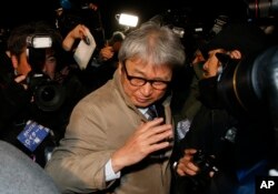 Motonari Otsuru, center, defense lawyer of former Nissan chairman Carlos Ghosn, is surrounded by journalists as he leaves the Tokyo Detention Center where Ghosn and another former executive Greg Kelly are being detained, in Tokyo, Dec. 20, 2018.