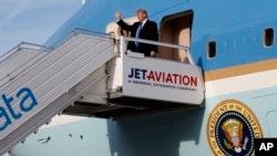 El presidente de EE.UU., Donald Trump, saluda al descender del Air Force One en el aeropuerto internacional de Zurich, Suiza, el jueves, 25 de enero de 2018.