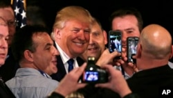 Republican presidential candidate, businessman Donald Trump smiles as he has his photograph taken with supporters after being endorsed at a regional police union meeting in Portsmouth, N.H., Thursday, Dec. 10, 2015.