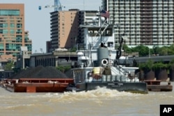 FILE - A tugboat pushes a barge loaded with coal up the Ohio River, past downtown Louisville, Kentucky.