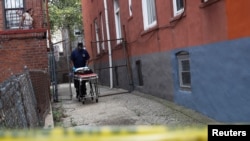 Seorang petugas membawa brankar kosong di lokasi dugaan pembunuhan di wilayah Brooklyn, New York, AS, 7 September 2020. (Foto: dok).
