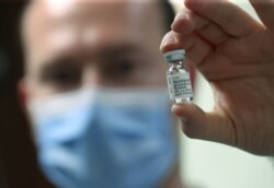 FILE - A pharmacist displays an ampoule of dexamethasone at the Erasme Hospital amid the COVID-19 outbreak, in Brussels, Belgium, June 16, 2020.