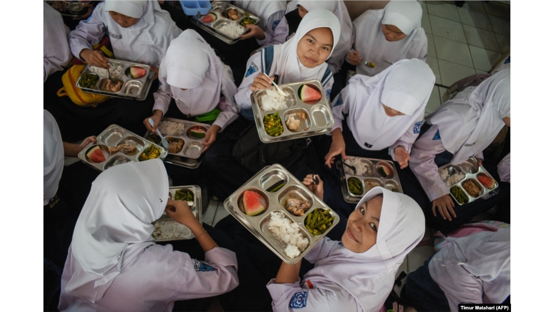 Siswa SMP Negeri 12 Cimahi, Jawa Barat, menikmati makan siang pada hari pertama program makan gratis, 6 Januari 2025. (Foto: Timur Matahari/AFP)