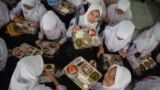 Siswa menikmati makan siang pada hari pertama program makan gratis di SMP Negeri 12 Cimahi, Jawa Barat, 6 Januari 2025. (Foto: Timur Matahari/AFP)