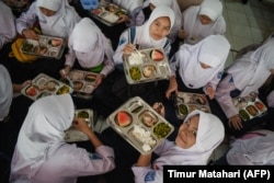 Siswa menikmati makan siang pada hari pertama program makan gratis di SMP Negeri 12 Cimahi, Jawa Barat, 6 Januari 2025. (Foto: Timur Matahari/AFP)