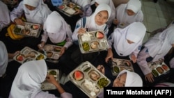 Siswa menikmati makan siang pada hari pertama program makan gratis di SMP Negeri 12 Cimahi, Jawa Barat, 6 Januari 2025. (Foto: Timur Matahari/AFP)