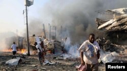 Warga sipil berjalan di lokasi ledakan di jalan KM4, distrik Hodan, Mogadishu, Somalia, 14 Oktober 2017. (Foto: dok).