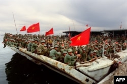 Bộ đội Việt Nam ngồi đợi trên tàu tại cảng Kampong Som, ngày 29 tháng 11, 1987. Những binh sĩ này thuộc một phần trong số 20.000 binh sĩ được rút khỏi Campuchia trong một đợt triệt thoái.