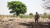 FILE - A Nigerian soldier stands amid the rubble of the Government Secondary School in Chibok, March 25, 2016. Schools are set to reopen in the region, where years of violence have decimated education. (C. Stein/VOA) 