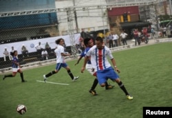 Players from Costa Rica and the Philippines (in blue shirts) compete during the "Street Soccer World Cup" in Sao Paulo, July 7, 2014.
