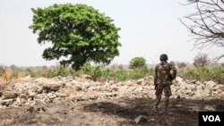 Un soldat se tient au milieu des ruines àChibok, Nigeria, le 25 mars 2016. (VOA/Chris Stein) 