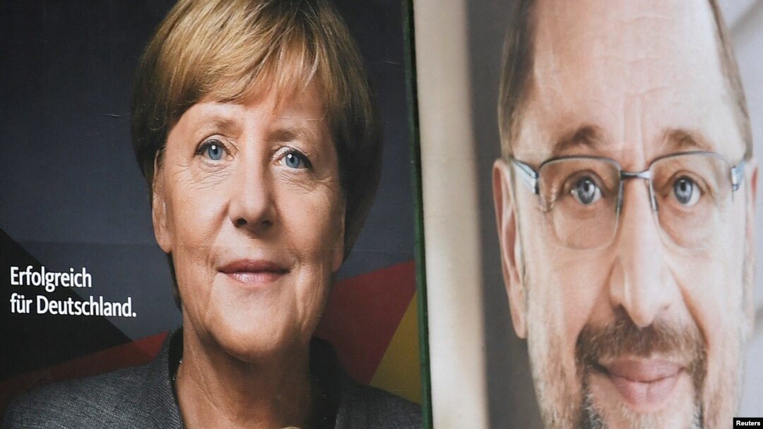 FILE - Election posters of German Chancellor Angela Merkel of the Christian Democratic Party (CDU) and Social Democratic Party (SPD) leader and top candidate Martin Schulz are seen in Hamburg, Germany, Sept. 24, 2017.