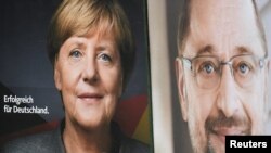 FILE - Election posters of German Chancellor Angela Merkel of the Christian Democratic Party (CDU) and Social Democratic Party (SPD) leader and top candidate Martin Schulz are seen in Hamburg, Germany, Sept. 24, 2017.