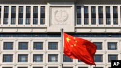 FILE - A Chinese national flag billows in front of Shandong Province Supreme People's Court in Jinan, eastern China, Oct. 24, 2013. Activists are calling on U.S. officials to put more focus on human rights in bilateral talks with China.