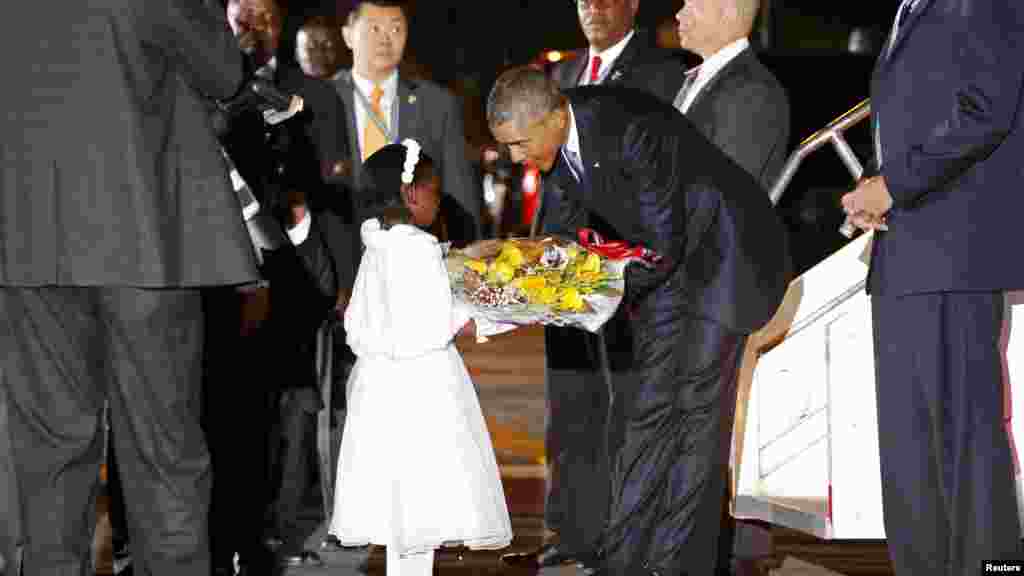 Le président américain Barack Obama reçoit des fleurs d&#39;une jeune fille après son arrivé &nbsp;à l&#39;aéroport international Jomo Kenyatta, Nairobi, 24 juillet 2015.