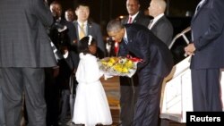 Presiden AS Barack Obama menerima karangan bunga dari seorang gadis kecil setibanya di bandara Internasional Jomo Kenyatta di Nairobi (24/7). 